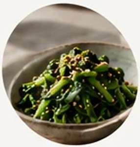 A bowl of seasoned spinach topped with sesame seeds