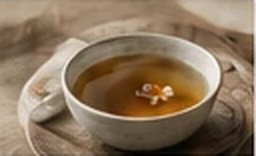 A cup of tea on a carved wooden tray